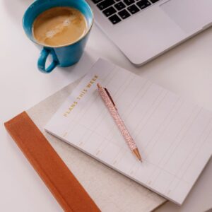 Still life of organizer weekly planner on table at home with coffee and pen